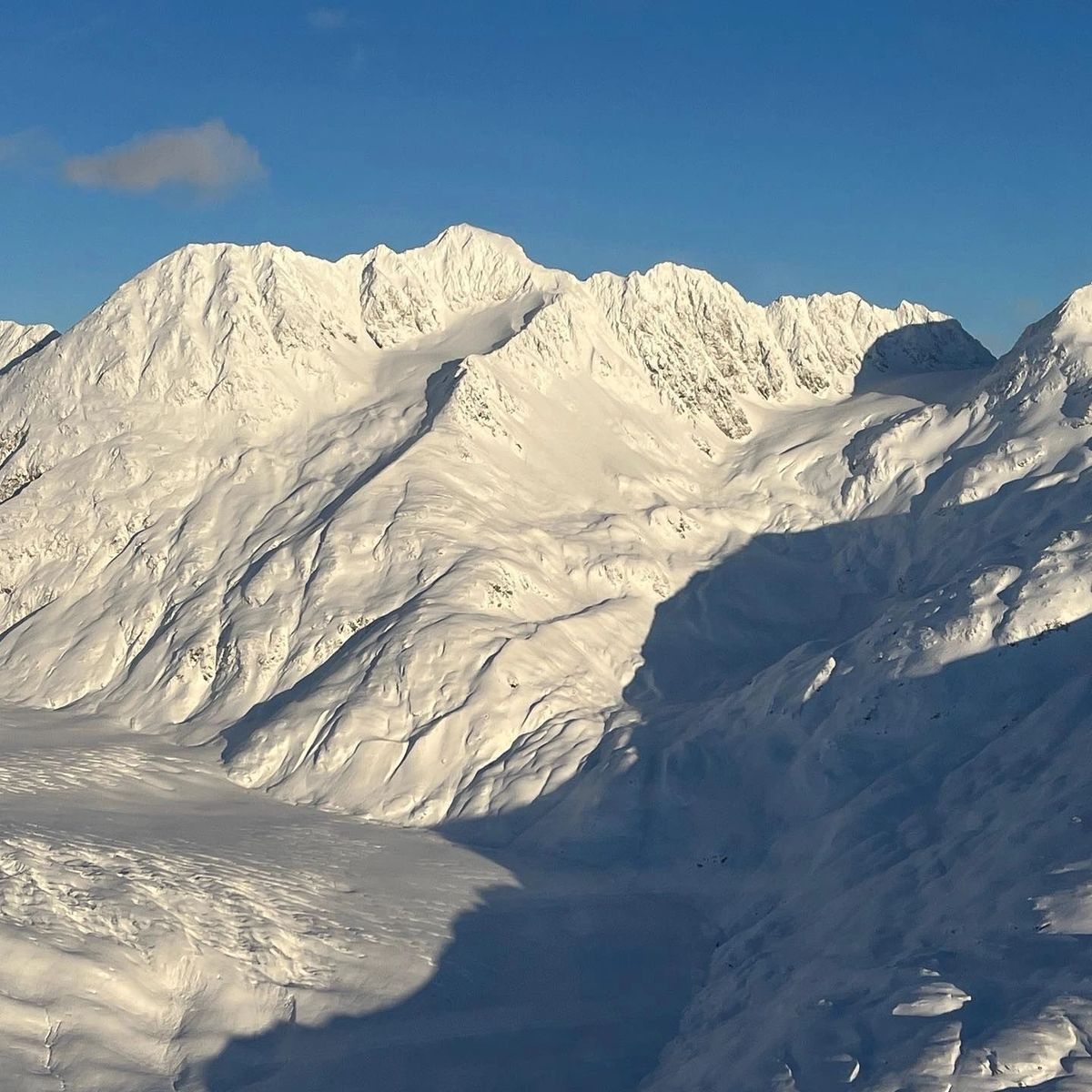 Snowy Alaskan mountain town surrounded by spruce forest and peaks