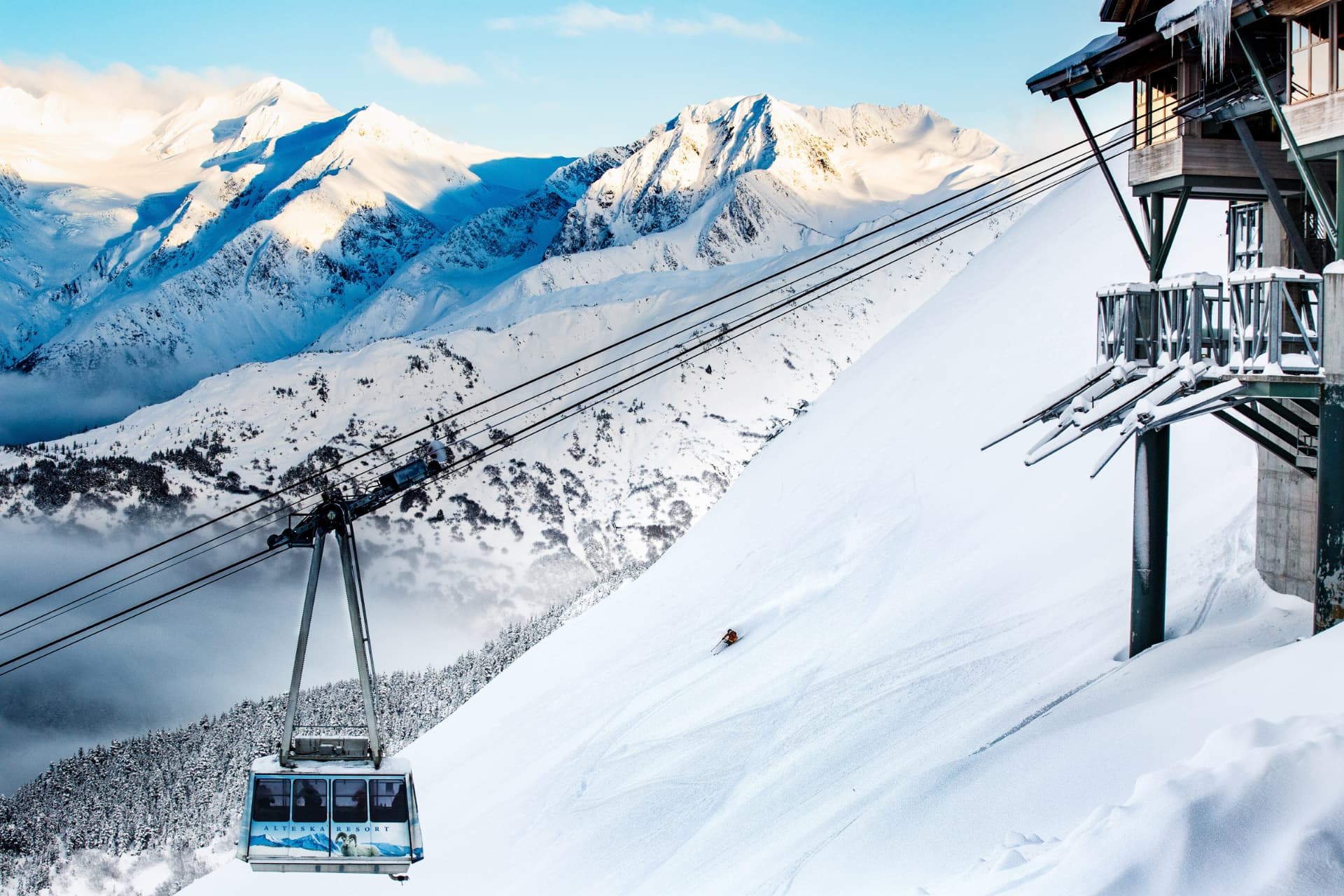 Alyeska Resort aerial tram above a skier on a powder slope