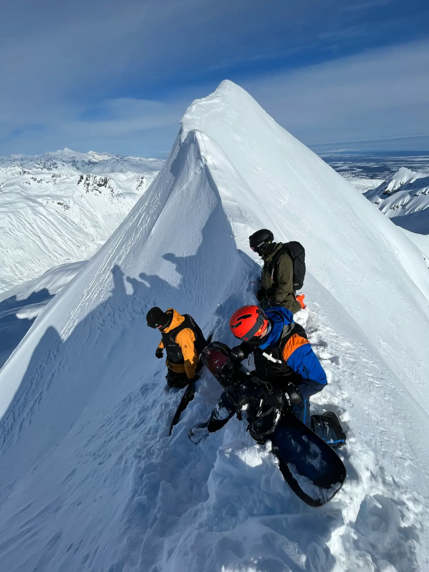 SMG guides and guests on a sharp snowy ridge in the Alaska backcountry