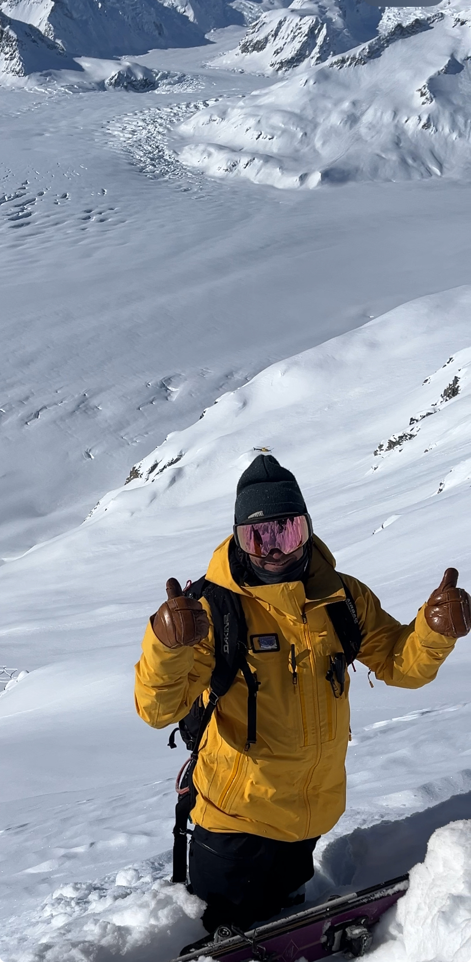 SMG guide in orange ski gear on a clear day in the Alaska backcountry