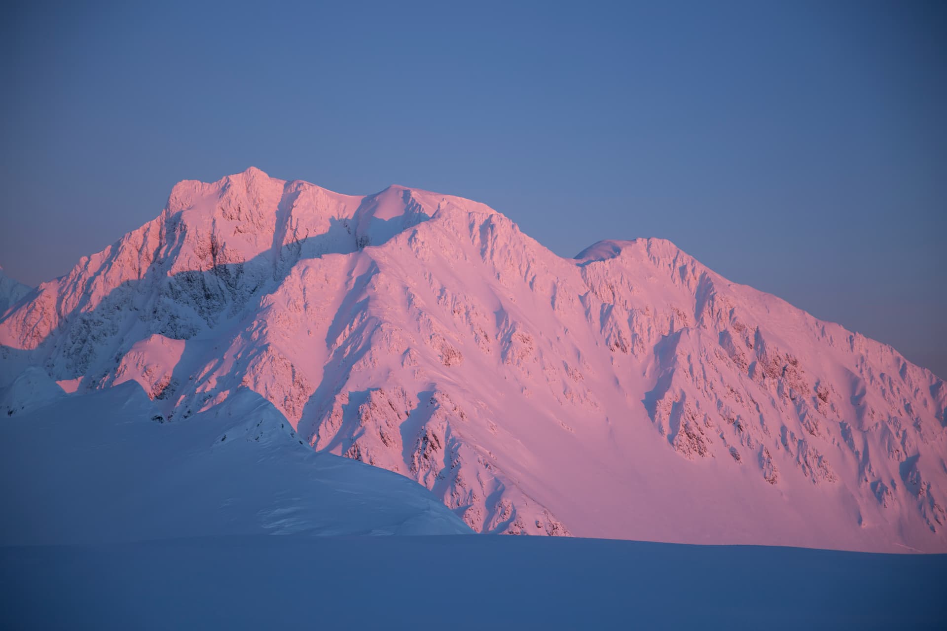 Alpenglow on snow-covered Alaskan peaks near Seward